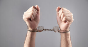 Caucasian male hands in handcuffs. Arrest